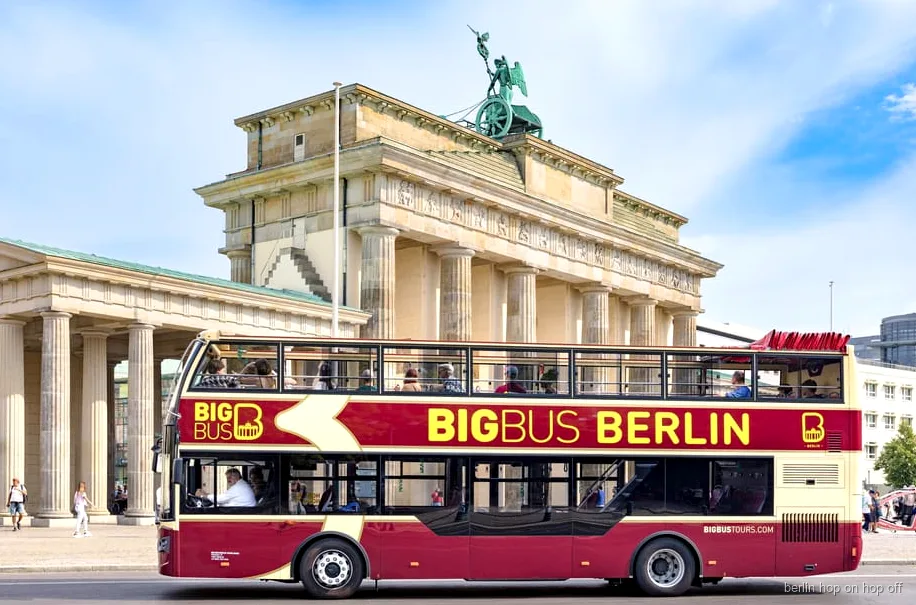 Big Bus Berlin hop-on hop-off tour open-top double-decker bus passing the Brandenburg Gate