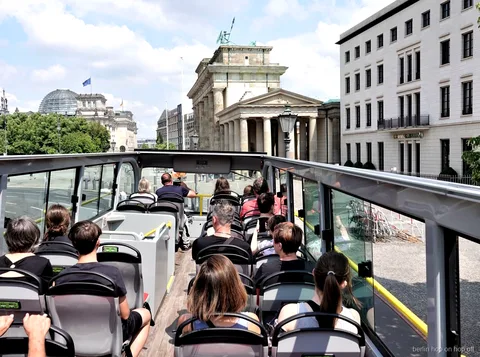 Passagers sur le pont ouvert du bus hop on hop off de Berlin face à la porte de Brandebourg