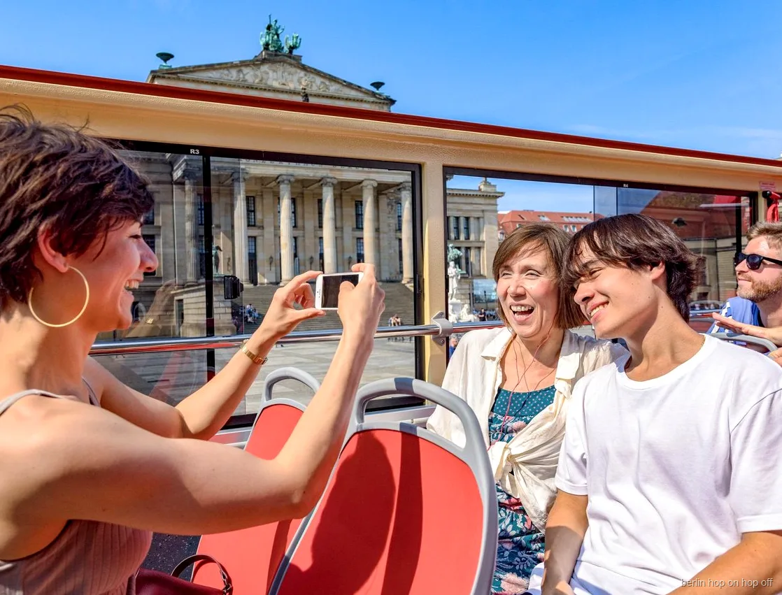 Passagers sur le pont ouvert du bus hop on hop off de Berlin prenant une photo au Gendarmenmarkt
