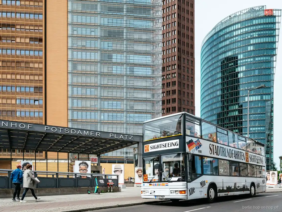 Bus de dos pisos del hop on hop off de Berlín a l'estació de Potsdamer Platz entre torres de vidre
