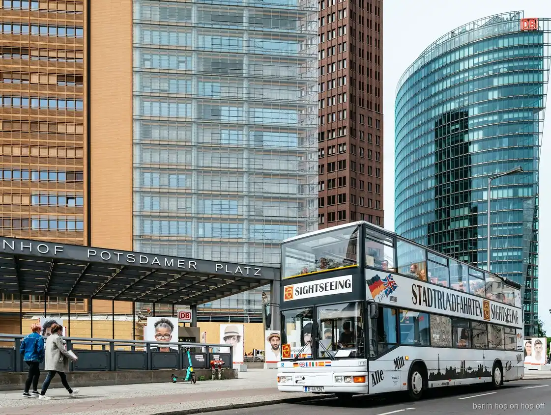 Autobús de dos pisos del hop on hop off de Berlín en la estación de Potsdamer Platz junto a torres de cristal