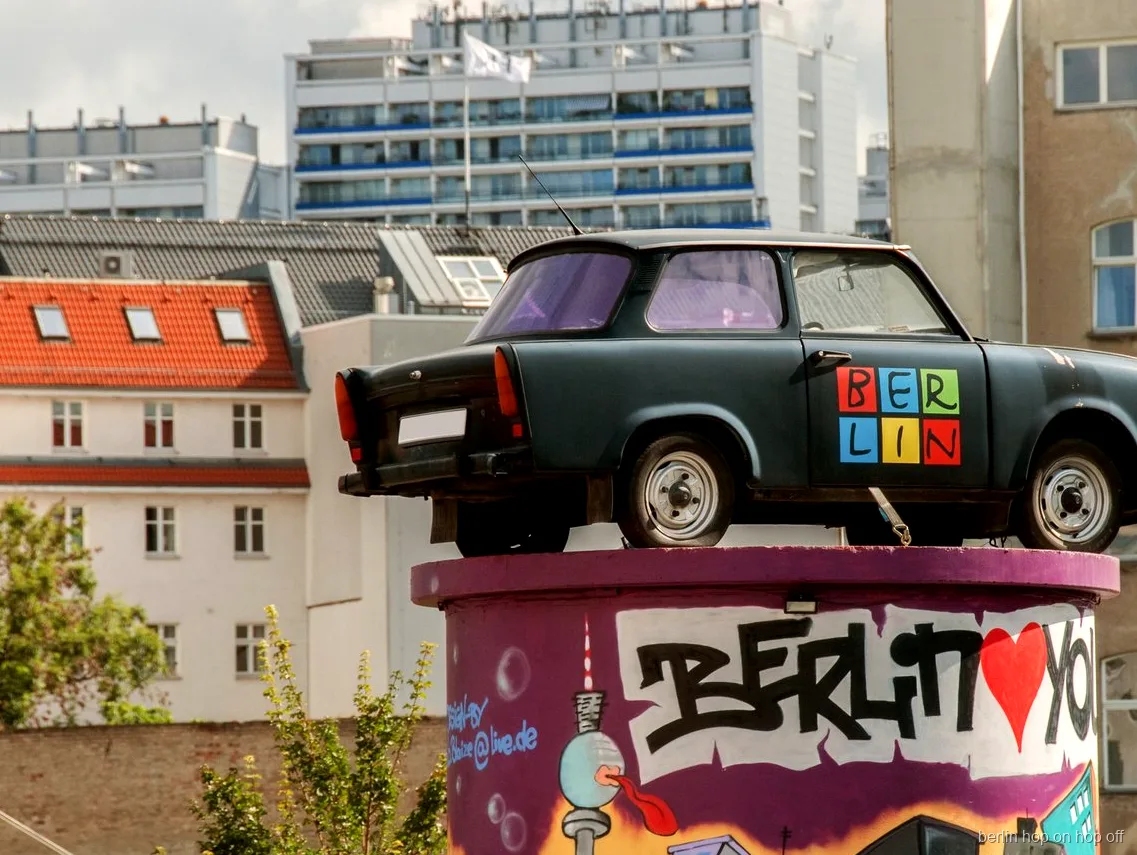 Coche Trabant sobre una columna con grafiti de Berlín en la ruta hop-on hop-off de City Sightseeing