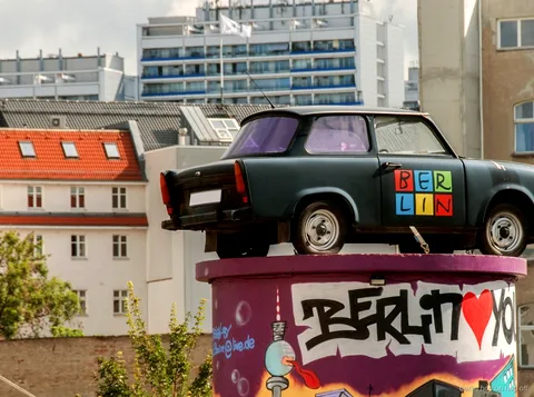 Berlin yazılı grafiti sütunu üzerinde Trabant, City Sightseeing Berlin hop-on hop-off güzergahında