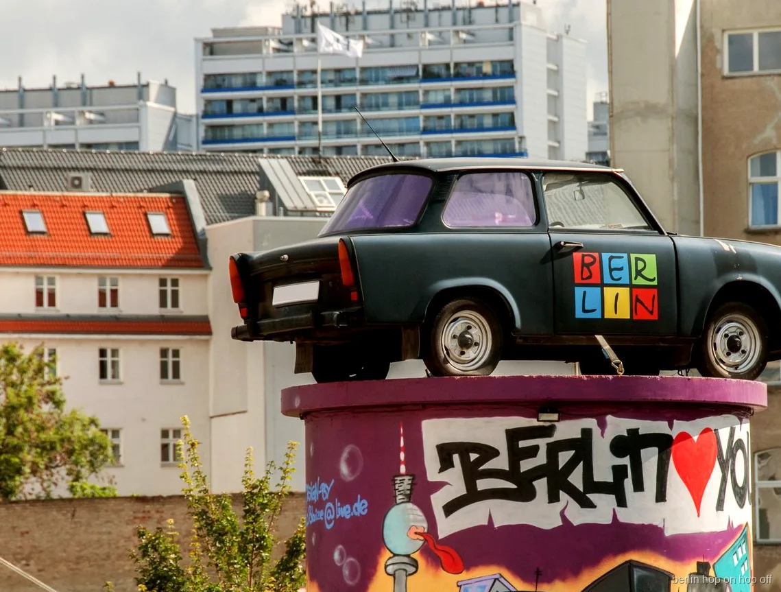 Trabant auf einer Graffiti-Säule mit Berlin Schriftzug an der City Sightseeing Berlin Hop-On Hop-Off Route