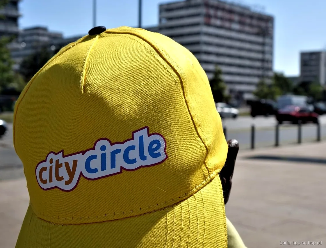 Güneşli bir sokakta logolu sarı City Circle şapkasının yakın çekimi, Berlin hop on hop off otobüsü