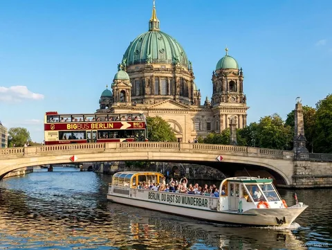 Big Bus Berlijn hop on hop off bus op een brug bij de Berliner Dom met een rondvaartboot op de Spree