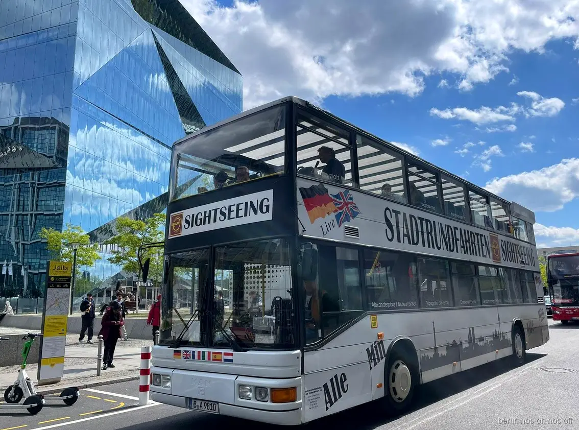 Witte Stadtrundfahrten Sightseeing dubbeldekker van de Berlijn hop on hop off tour bij een glazen gebouw