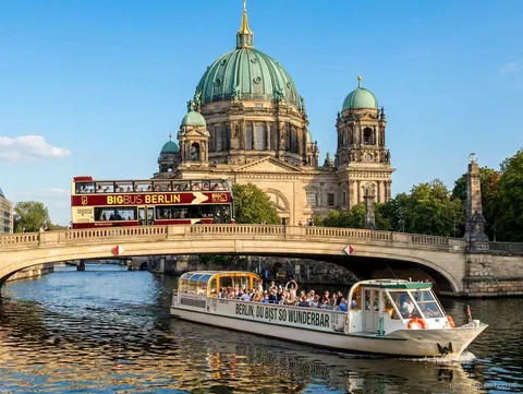 Big Bus Berlin hop on hop off buss på en bro vid Berliner Dom med en Spree-båt på floden