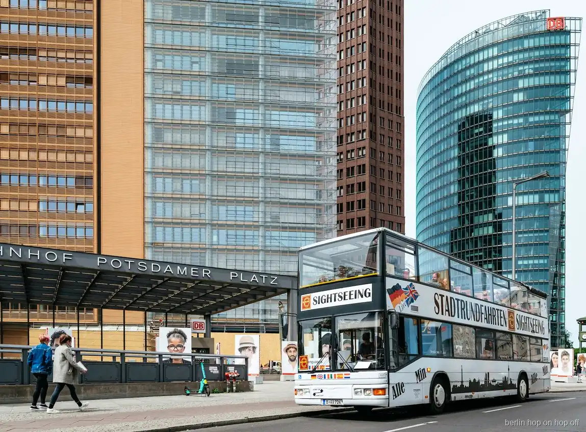 Piętrowy autobus hop on hop off w Berlinie przy stacji Potsdamer Platz obok szklanych wież