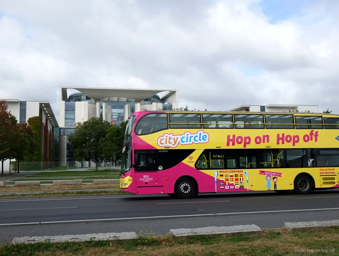 Bus a due piani rosa e giallo City Circle Berlino hop on hop off davanti alla Cancelleria federale