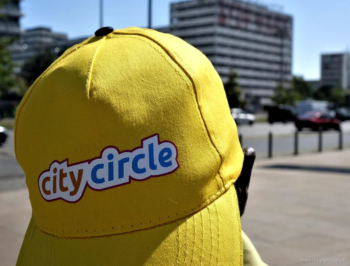 Zbliżenie na żółtą czapkę City Circle z logo na słonecznej ulicy, autobus hop on hop off w Berlinie