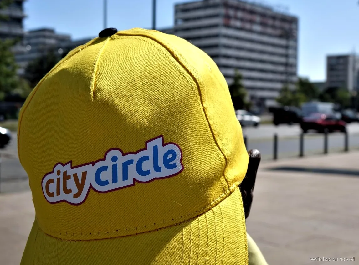 Tæt på en gul City Circle kasket med logo på en solrig gade, Berlin hop on hop off bussen